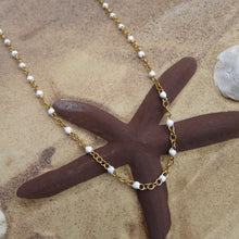 Load image into Gallery viewer, Necklace with white beads and gold chain on a starfish and stone background