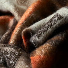 Load image into Gallery viewer, Close-up view of a bunched up scarf in white, orange, black, and brown.