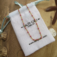 Load image into Gallery viewer, Gold chain necklace with pink beads on a Salty Cat Jewelry pouch against a natural background