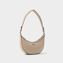 Load image into Gallery viewer, A light taupe small shoulder bag with  black trim in a  crescent shape.  "HW" in brown on the front, in front of a white background.
