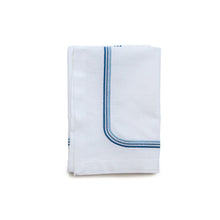 Load image into Gallery viewer, A white cotton napkin with three blue embroidered lines on the edge, neatly folded.