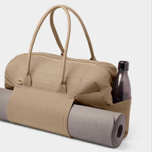 Load image into Gallery viewer, A beige gym bag with a side mat holder and a gray yoga mat inside, and a gray clear water bottle in side pocket. White background.