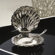 Load image into Gallery viewer, Polished nickel fan shell lidded bowl with matching spoon displayed open and partially filled with a white contents, displayed on a black reflective surface with a white background and a silver glittered decorative piece.