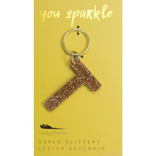 Load image into Gallery viewer, Gold glittery letter &quot;T&quot; keychain on a yellow card with &quot;you sparkle&quot; in gold text, displayed against a white background. 