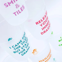 Load image into Gallery viewer, Close-up of frosted stacked plastic cups printed with colorful Mahjong-themed sayings such as "SMILES &amp; TILES" in purple, "RELEASE YOUR INNER DRAGON" in red, "I CAME FOR THE TILES BUT STAYED FOR THE DRAMA" in teal, and "MAHJONG MOOD" in mustard, displayed on a white background.