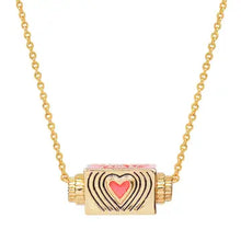 Load image into Gallery viewer, Close-up of the gold-plated rectangular spinner pendant necklace with a red heart motif and a radiating line design , displayed suspended on a white background. 
