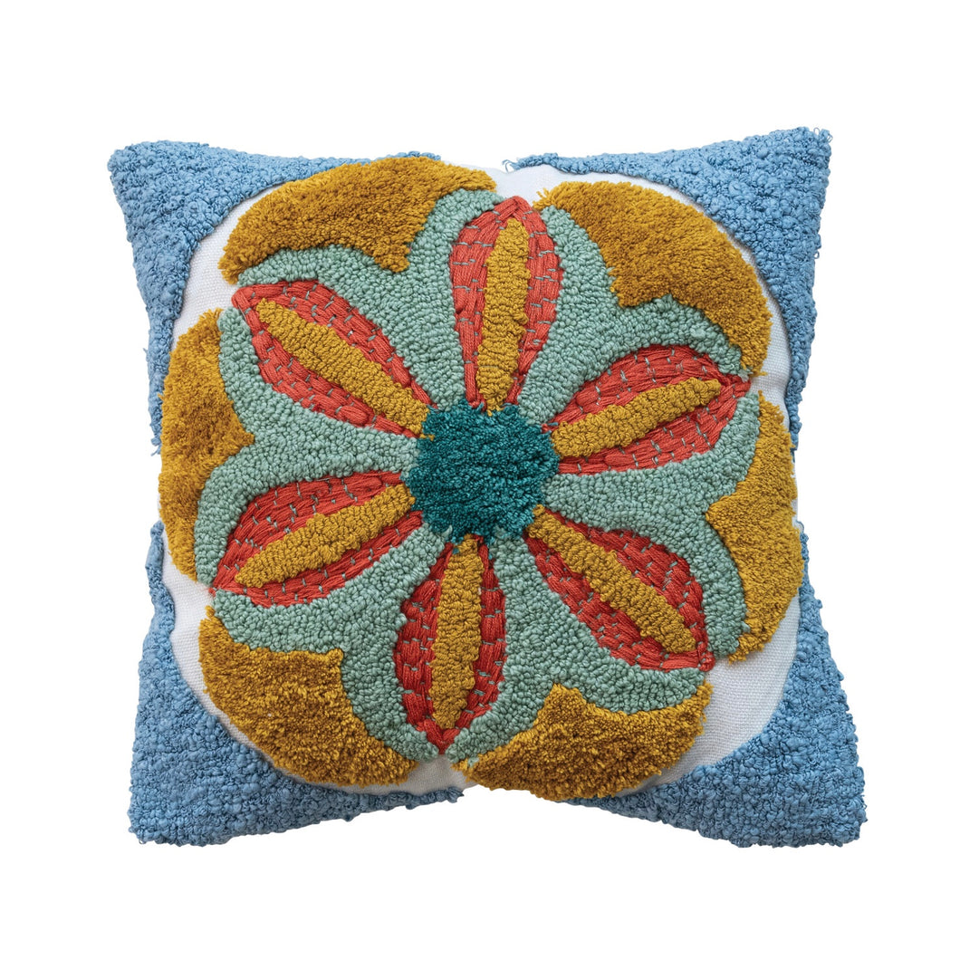 A square-shaped tufted pillow with a floral pattern in blue, red, and yellow colors. On a white background.