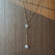 Load image into Gallery viewer, Freshwater Pearl Drop Y Necklace, close-up view of a delicate 14k gold-filled chain forming a Y shape with two flattened, irregular freshwater pearls and a small round pearl spaced along the vertical drop, displayed against a textured woven background.