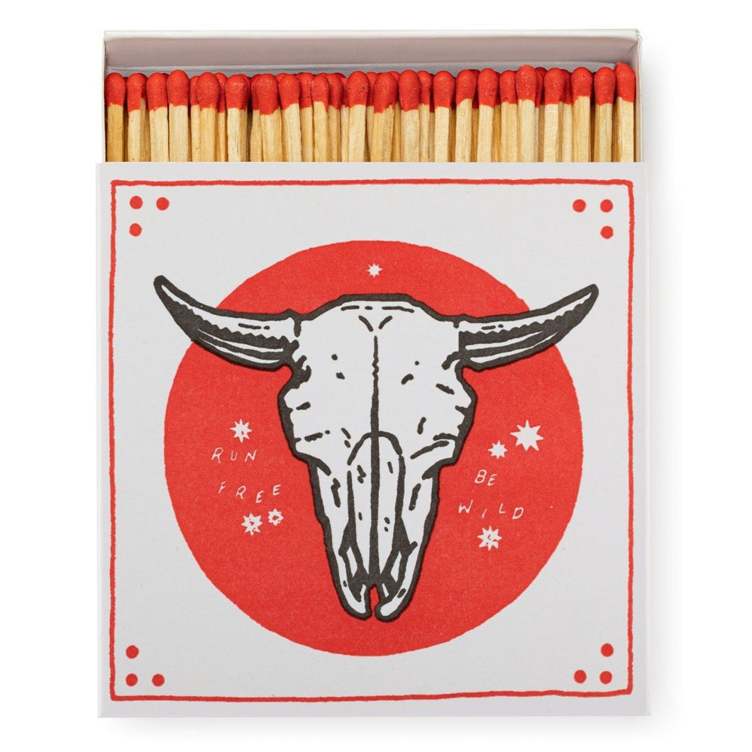 A white opened box of matches with a bull head skeleton in a red circle . Red tipped matches. On a white background. 