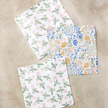Load image into Gallery viewer, Geometry dishcloths with green and pink floral pattern and multicolor wildflower pattern on separate towels, on a marble surface.