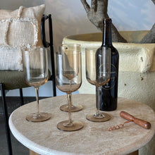 Load image into Gallery viewer, Four crystal red wine glasses in an organic color, styled with a wine bottle on a marble table.
