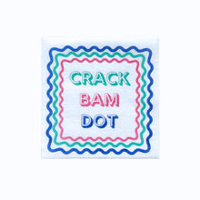 Load image into Gallery viewer, White cocktail napkin printed with the words "CRACK BAM DOT" in colorful lettering and framed in wavy multicolored borders, displayed on a white background. 