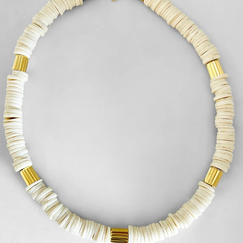 Necklace with white beads and gold accents on a light gray background