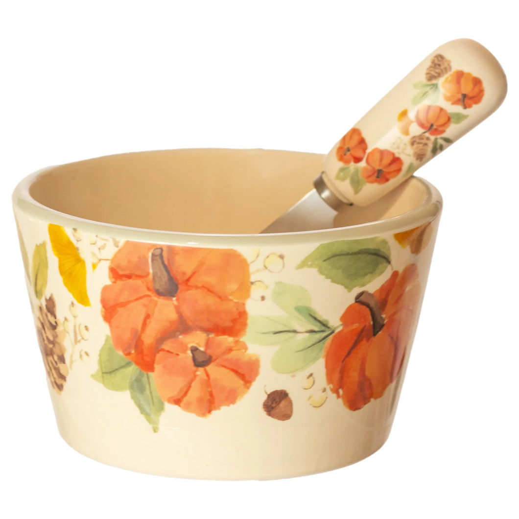 Matching bowl and spreader set with a pumpkin and pinecone design on a white background.