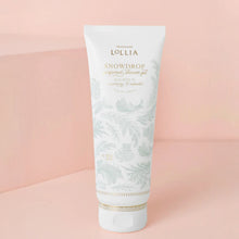 Load image into Gallery viewer, Lollia Snowdrop body wash gel in a pale blue botanical-print tube, displayed against a powder pink background. 