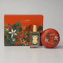 Load image into Gallery viewer, Granado Oud gift set with decorative floral orange box, travel-size glass cologne bottle with gold cap, and round orange floral-wrapped Oud bar soap displayed on a white background. 