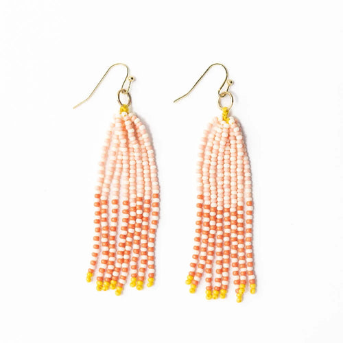 A pair of beaded earrings with pink and peach colored beads and yellow accents, hanging from gold-colored hooks, against a white background.