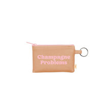 Load image into Gallery viewer, Beige vegan leather pouch with a pink zipper and a silver key ring, printed with the phrase &quot;Champagne Problems&quot; in light pink retro lettering, displayed against a white background.  