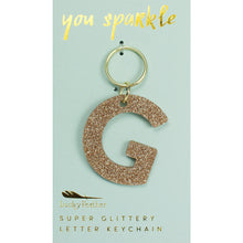 Load image into Gallery viewer, Gold glittery letter &quot;G&quot; keychain on a light blue card with &quot;you sparkle&quot; in gold text, displayed against a white background. 