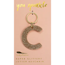 Load image into Gallery viewer, Gold glittery letter &quot;C&quot; keychain on a pink card with &quot;you sparkle&quot; in gold text, displayed on a white background. 