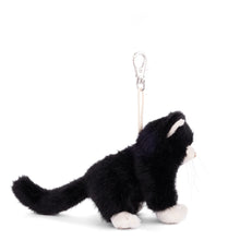 Load image into Gallery viewer, Side of a black and white plush cat with a long black tail and silver clasp displayed on a white background.