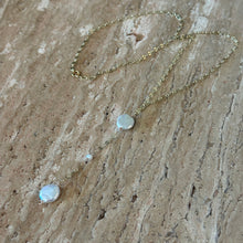 Load image into Gallery viewer, Freshwater Pearl Drop Y Necklace, overhead view of a delicate 14k gold-filled chain arranged on a textured beige stone surface, showing its clasp and Y-shaped drop with two flattened, irregular freshwater pearls and a small round pearl between them.