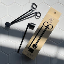 Load image into Gallery viewer, Matte black metal wick trimmer and candle snuffer next to its packaging box, displayed on a white tile surface.