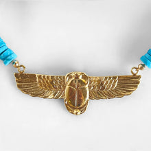 Load image into Gallery viewer, A gold winged beetle pendent with turquoise beads on each side of a white background.
