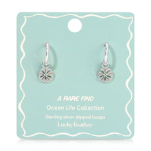 Load image into Gallery viewer, Pair of sterling silver-dipped hoop earrings with small round sand dollar charms displayed on a mint green &quot;A Rare Find&quot; Ocean Life Collection card by Lucky Feather with white wavy border detailing, displayed against a white background. 