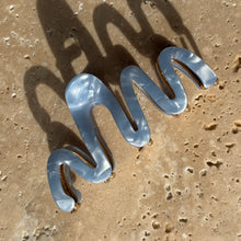 Load image into Gallery viewer, Coastal blue wavy claw clip with gold metal hardware displayed on a beige travertine surface with soft shadows.