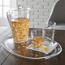 Load image into Gallery viewer, Clear embossed fish pitcher with lid and glasses filled with ice and an amber-colored beverage, arranged on a matching oval serving tray on a wooden table with a white brick background. 
