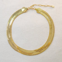 Load image into Gallery viewer, Wide gold-plated brass herringbone chain necklace with an adjustable clasp, displayed flat on an off-white textured surface.  