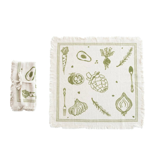 White squares napkin with fringe. One large unfolded one, one small folded one tied with a bow to the side. Green vegetable print. White background. 