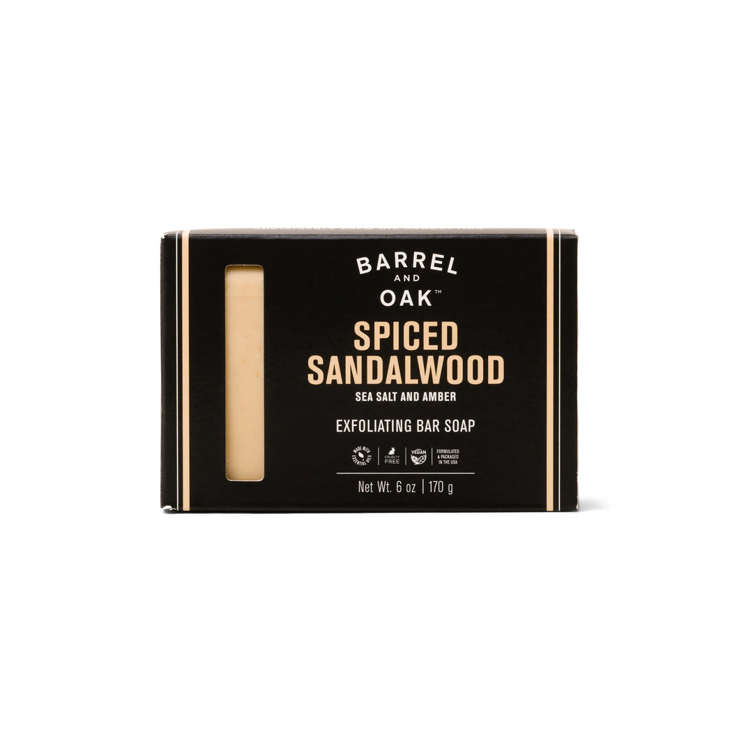 Black cardboard box of yellow soap in the scent spiced sandalwood. White background. 