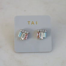 Load image into Gallery viewer, Pair of gold-tone emerald-cut cluster stud earrings with pastel crystal accents, displayed on a light gray TAI jewelry card against a white background. 