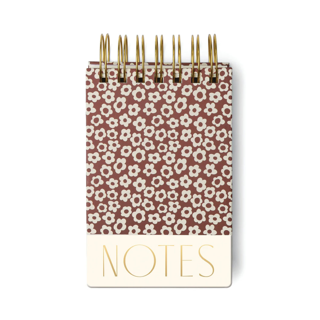Spiral flip notebook printed with white flowers on a brown background. White background. 