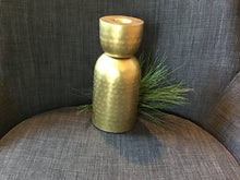 Load image into Gallery viewer, Tall stamped brass taper candlestick holder with textured finish against gray background with greenery. 