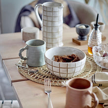 Load image into Gallery viewer, Dining table setting with various ceramic mugs, bowls, and cutlery on a woven placemat.