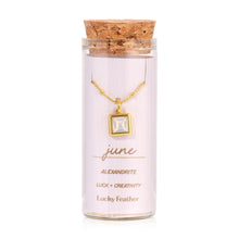 Load image into Gallery viewer, June birthstone necklace featuring a square alexandrite-colored glass crystal pendant framed in 14K gold-dipped metal, displayed inside a clear glass bottle with a cork lid and a label card reading "June - Alexandrite - Luck + Creativity," displayed against a white background.