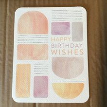 Load image into Gallery viewer, Birthday greeting card laying face up on a brown cardboard surface. Card reads: &quot;HAPPY BIRTHDAY WISHES&quot; in orange and purple print. Card has peach, orange, purple, and gray geometric shapes and set of gray lines. 