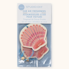 Load image into Gallery viewer, Pack of Studio Oh! car air fresheners with a pink shell design, trimmed in a cream color. Shells have blue strings with cream colored beads for hanging. Air freshener in a clear plastic baggie with a white paper top quarter with the words "STUDIO OH!", "CAR AIR FRESHENERS", and "TROPICAL &amp; CITRUS FRUITS" Against a white background.