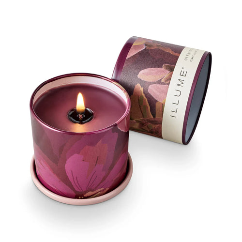 Purplish candle in a decorative tin with 'ILLUME' packaging on a white background