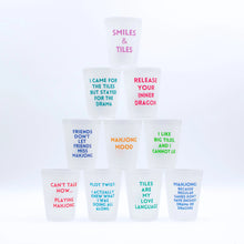 Load image into Gallery viewer, Set of frosted plastic cups stacked in a pyramid, each printed with colorful Mahjong-themed sayings such as "SMILES &amp; TILES" in purple, "MAHJONG MOOD" in mustard, and eight others, displayed on a white background.