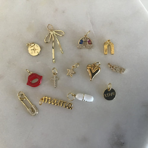 An assortment of gold charms on a marble background. 