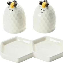 Load image into Gallery viewer, A pair of matching white salt and pepper shakers in the shape of a beehive, adorned with a yellow and black bee on top. A white double hexagon shaped tray for carrying shakers, against a white background.