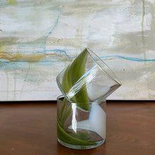 Load image into Gallery viewer, Splash Cups hand-blown clear glass set of two with abstract pistachio green and white swirled design, one stacked inside the other on wooden surface against abstract background. 