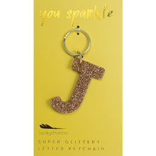 Load image into Gallery viewer, Gold glittery letter &quot;J&quot; keychain on a yellow card with &quot;you sparkle&quot; in gold text, displayed against a white background. 