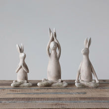 Load image into Gallery viewer, A set of three antiqued white colored resin rabbit figurines in different yoga poses, placed on a wooden surface against a neutral background.