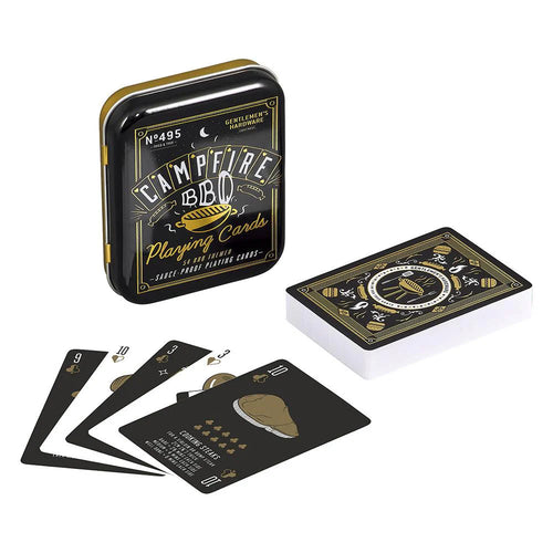 Black tin box with campfire barbecue print. Six black and white playing cards arranged in front. White background. 