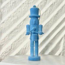 Load image into Gallery viewer, Blue nutcracker ornament holding a small drum and drumsticks, standing upright with a gold hanging cord against a white textured background.  